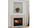 Close up of a tile fireplace with decorative plant shelf and working fire at 1505 Blaze Ln, Charleston, SC 29412