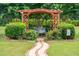 Idyllic backyard garden featuring a wooden arbor, bench seating, and lush landscaping at 1505 Blaze Ln, Charleston, SC 29412