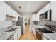 Galley kitchen with stainless steel appliances, marble countertops, and light wood floors at 1505 Blaze Ln, Charleston, SC 29412