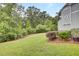 A view of the backyard featuring a large, green lawn and dense trees and landscaping at 1550 Spring Moss Rd, Mount Pleasant, SC 29466