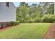 Spacious backyard with green grass, mulch beds, and mature trees offering privacy at 1550 Spring Moss Rd, Mount Pleasant, SC 29466