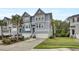 Townhome showcasing a blue exterior, two-car garage, palm trees and driveway at 1550 Spring Moss Rd, Mount Pleasant, SC 29466