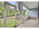 Relaxing screened-in porch with white railings, a concrete floor, offering views of the lush green yard at 1550 Spring Moss Rd, Mount Pleasant, SC 29466