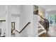 Elegant staircase with hardwood steps, white risers, a stained wood handrail, and stylish decor at 1550 Spring Moss Rd, Mount Pleasant, SC 29466