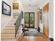 Elegant foyer with hardwood floors, staircase with iron railings, and natural light flooding through glass doors at 1612 John Fenwick Ln, Johns Island, SC 29455