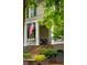 Inviting front porch features classic white columns, brick stairs, and cozy seating, enhancing curb appeal at 1612 John Fenwick Ln, Johns Island, SC 29455