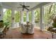 Relaxing screened porch with wood floors and white columns provides a serene outdoor dining space at 1612 John Fenwick Ln, Johns Island, SC 29455