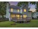Backyard of a two-story home featuring a deck, lush green lawn, and exterior lighting at 1616 Dotterers Run, Charleston, SC 29414
