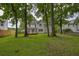 Home exterior with backyard showing mature trees, a lush green lawn and outdoor deck at 1616 Dotterers Run, Charleston, SC 29414