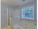 A bathtub with tiled enclosure sits beneath a bright window at 1616 Dotterers Run, Charleston, SC 29414