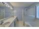 Bright bathroom featuring a double sink vanity, large mirror, tub, and glass-enclosed shower at 1616 Dotterers Run, Charleston, SC 29414