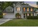 Charming two-story home featuring a manicured front lawn, a two-car garage, and a cozy front porch at 1616 Dotterers Run, Charleston, SC 29414