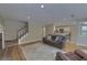 Open living room with hardwood floors, brick fireplace, stairway, and an open view to the kitchen at 1616 Dotterers Run, Charleston, SC 29414