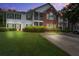 Inviting two-story condo with a brick facade, screened porch, lush lawn, and a private driveway at dusk at 163 Golfview Ln, Summerville, SC 29485