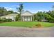Garage with white siding, green trim, and surrounded by beautiful greenery and landscaping at 163 Golfview Ln, Summerville, SC 29485