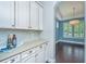 Convenient butler's pantry with white cabinets, granite countertop, and tiled backsplash at 1721 Wellstead St, Mount Pleasant, SC 29466