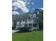 Charming two-story home with a well-manicured lawn, complemented by mature palm trees and a welcoming front porch at 1721 Wellstead St, Mount Pleasant, SC 29466