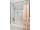 Bright bathroom featuring a white subway tiled shower and tub, accented by a charming pink curtain at 1809 Rushland Grove Ln, Johns Island, SC 29455
