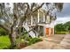 Exterior view of a beautiful two-story home framed by lush greenery and spanish moss at 1809 Rushland Grove Ln, Johns Island, SC 29455