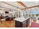 Open-concept kitchen features an island with quartz countertop, wooden beams, and views of the living and dining areas at 1809 Rushland Grove Ln, Johns Island, SC 29455