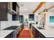 Modern kitchen with stainless steel appliances, including a gas range, complemented by black cabinets and hardwood floors at 1809 Rushland Grove Ln, Johns Island, SC 29455