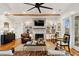 Stylish living room with a brick fireplace, built-in shelving, ceiling fan, and views to the outdoors at 1809 Rushland Grove Ln, Johns Island, SC 29455