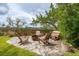 Relax in the outdoor seating area, featuring a fire pit and comfortable wooden chairs surrounded by lush greenery at 1809 Rushland Grove Ln, Johns Island, SC 29455