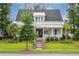 Charming two-story home featuring a well-manicured lawn, lush landscaping, and inviting front porch at 1903 Bolden Dr, Mount Pleasant, SC 29466