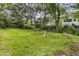 Spacious backyard with a stone fire pit and a lush green lawn surrounded by mature trees at 1909 Swift Ave, Charleston, SC 29407