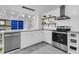 Modern kitchen features stainless steel appliances, white cabinets, granite counters, and stylish hanging lights at 1909 Swift Ave, Charleston, SC 29407