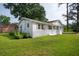 Side view of a white brick ranch-style home with a red roof, attached garage, and well-manicured lawn at 2058 Bishop Dr, Charleston, SC 29414