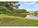 Lush backyard with a serene pond and mature trees, offering a peaceful outdoor retreat at 241 Clayburne Dr, Goose Creek, SC 29445