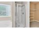 Modern bathroom boasts a glass-enclosed shower, a window, and a walk-in closet with shelving for storage at 241 Clayburne Dr, Goose Creek, SC 29445