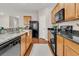Well-lit kitchen featuring granite countertops, stainless steel appliances, wooden cabinetry, and hardwood floors at 241 Clayburne Dr, Goose Creek, SC 29445