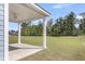 A covered patio with white pillars overlooks a spacious, green backyard at 2477 Sawlog Ln, Summerville, SC 29486
