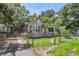 Charming single-story home with a grassy front yard, chain link fence, and mature trees providing ample shade at 2665 Ranger Dr, North Charleston, SC 29405