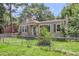 A quaint one-story home featuring shutters, a chimney, green grass and a chain-link fence at 2665 Ranger Dr, North Charleston, SC 29405