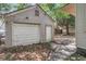 View of detached two-car garage featuring a side door and a weathered vinyl siding exterior at 2665 Ranger Dr, North Charleston, SC 29405