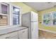 Bright kitchen featuring yellow walls, a white refrigerator, and a large window with natural lighting at 2665 Ranger Dr, North Charleston, SC 29405