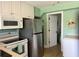 Kitchen featuring stainless steel refrigerator and microwave with white cabinets and tile floor at 287 Driftwood Ln, Edisto Beach, SC 29438