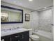 A well-lit bathroom features a tub with shower, modern vanity with marble countertop, and blue-framed mirror for modern living at 2909 Atrium Villa, 9, Seabrook Island, SC 29455