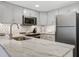 Well-lit kitchen featuring granite countertops, stainless steel appliances, and gray cabinets at 2909 Atrium Villa, 9, Seabrook Island, SC 29455