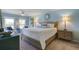 Comfortable bedroom with pale blue walls, a ceiling fan, large bed, and natural light from the windows overlooking the outdoors at 2909 Atrium Villa, 9, Seabrook Island, SC 29455