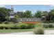 The Del Webb at Cane Bay entrance sign surrounded by lush landscaping and colorful flower beds at 310 Waterlily Way, Summerville, SC 29486