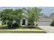 Charming home with a well-manicured lawn, mature trees, and inviting front porch at 310 Waterlily Way, Summerville, SC 29486