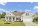 Charming home featuring a two-car garage, well-manicured lawn, and inviting front porch with comfortable seating at 349 Waterlily Way, Summerville, SC 29486