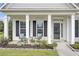 Charming front porch with white columns, black shutters, and comfortable seating, perfect for enjoying the outdoors at 349 Waterlily Way, Summerville, SC 29486