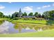 Scenic pond view with 'Del Webb at Cane Bay' sign and lush green surroundings at 349 Waterlily Way, Summerville, SC 29486