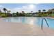 A sunny outdoor swimming pool, with palm trees, lounge chairs and red umbrellas at 349 Waterlily Way, Summerville, SC 29486