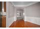 Warm foyer with hardwood floors transitions seamlessly into a hallway with white wainscoting and archway at 361 Waterlily Way, Summerville, SC 29486